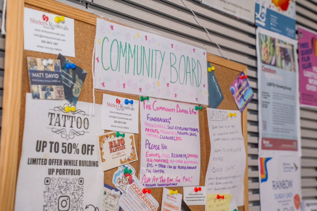 Community noticeboard at the London LGBTQ+ Community Centre with business cards, offers and print outs.